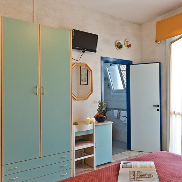 Bright room with green wardrobe and private bathroom.